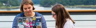 Two U N E students study on the waterfront of the Biddeford campus